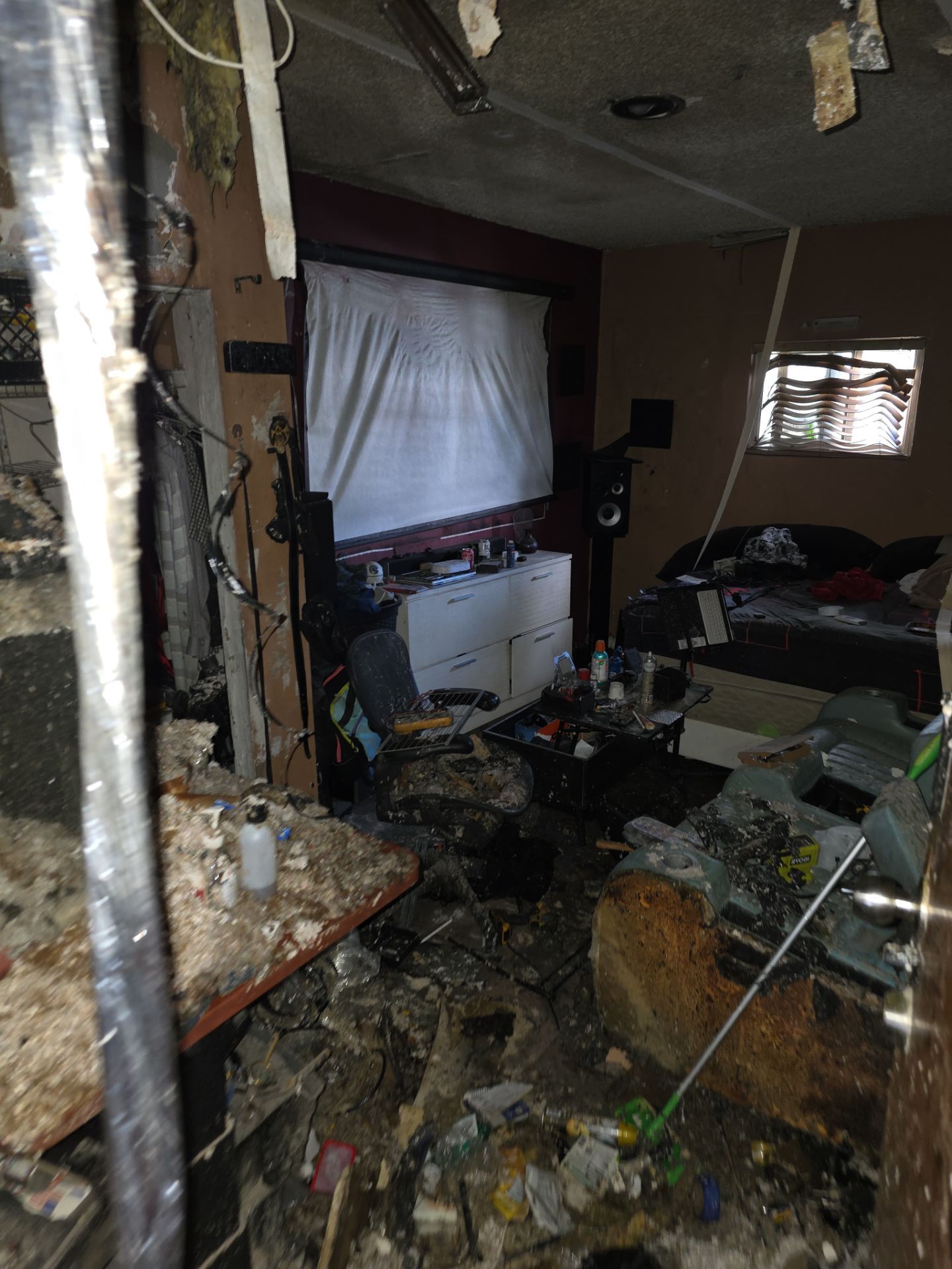 Bedroom destroyed by fire with collapsed ceiling and debris